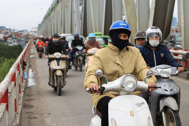 Chùm ảnh: Người dân Hà Nội khoác cả chăn bông, mặc áo mưa xuống phố để tránh rét